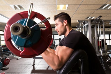 biceps preacher bench arm curl workout man at gym
