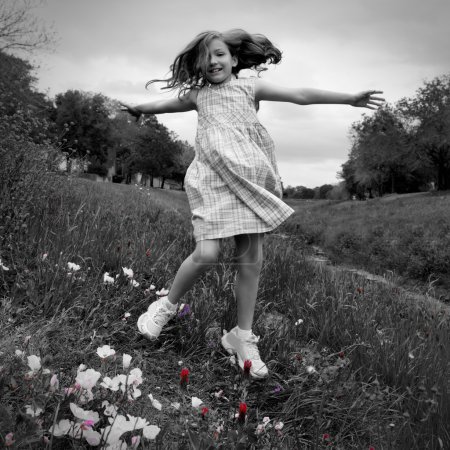 happy children girl jumping on spring poppy flowers