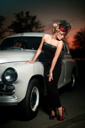 Beautiful sexy woman standing near old car in retro style