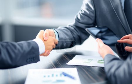 Business shaking hands in office