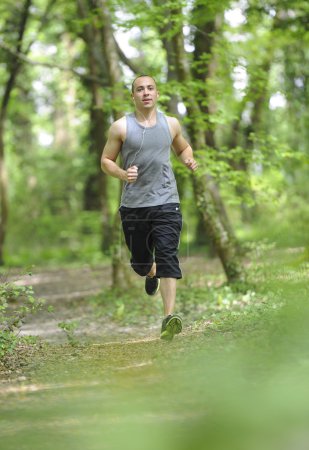 Young man running in the woods