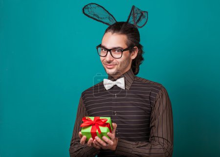 Fashion guy in bunny ears of holding gift. valentine's day