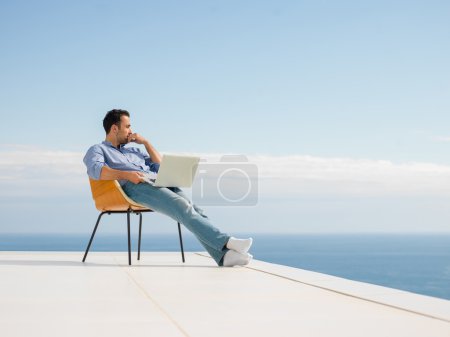 Relaxed young man at home on balcony