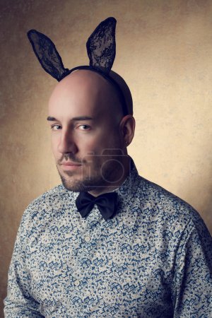 Portrait of a handsome glamourous bald bunny-man posing over gol