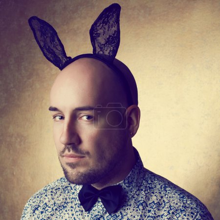 Vintage portrait of a handsome glamorous bald bunny-man posing o