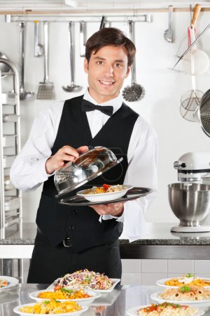 Waiter Lifting The Cover Of Cloche