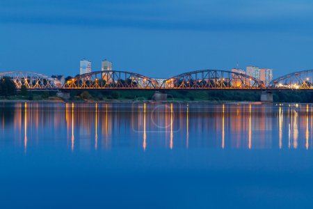 Bridge of Grudziadz at night reflected in Wisla river