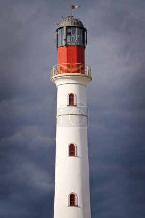 White lighthouse over dramatic sky