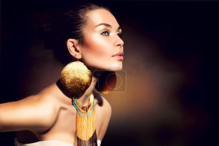 Fashion Woman Portrait. Golden Jewels. Trendy Makeup