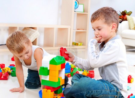 Children Boys playing with construction set on the floor