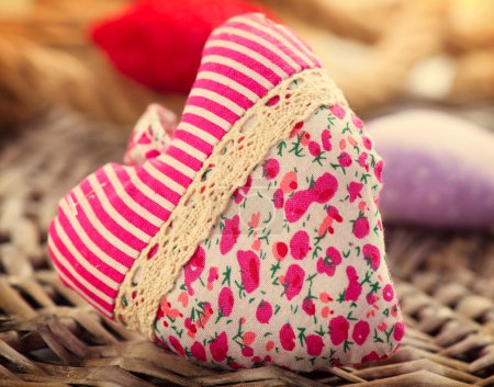 Valentine's Day. Handmade fabric heart over wood background