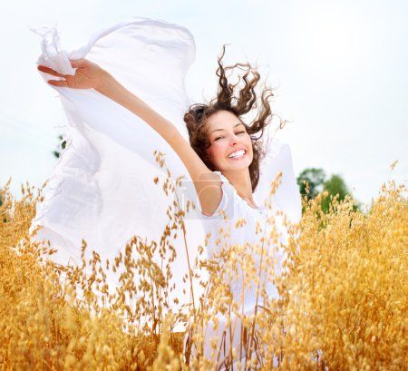 Beautiful Happy Girl on the Wheat Field