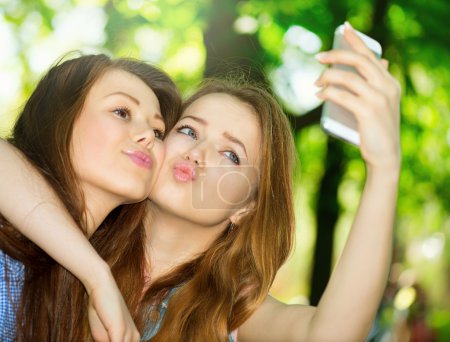 Teen friends taking photos with a smartphone.
