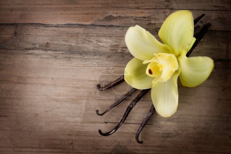 Vanilla Pods and Flower over Wooden Background
