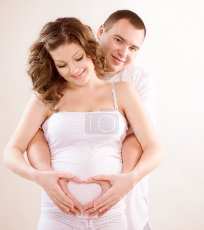 Happy Couple Expecting Baby. Pregnant Belly with fingers Heart s