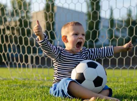 Boy with football shouting with glee