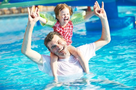 Father and child in resort swimming pool