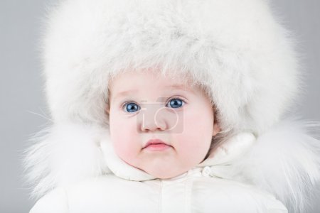 Baby girl wearing a big fur hat