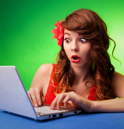 Surprised young woman at a computer