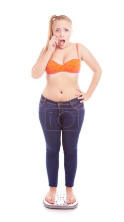 Size 40 girl standing on a bathroom scale, overweight and diet concept