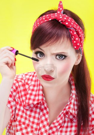 Funny portrait of girl applying mascara