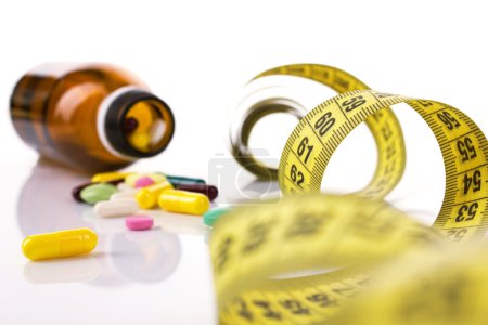 diet concept with pills and centimeter