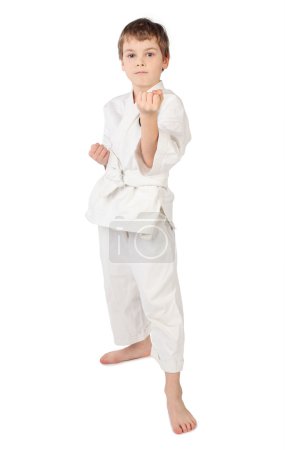 Karateka boy in white kimono standing isolated on white backgrou