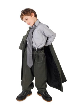 Little boy in big grey man's suit and boots dressing jacket isol