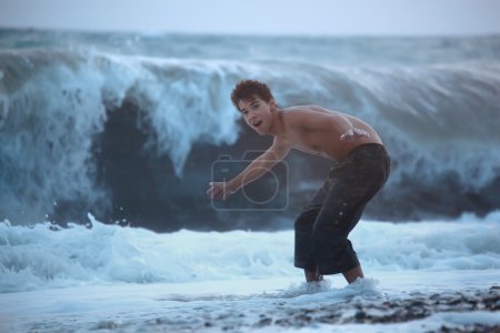 Teenager escaping from sea wave