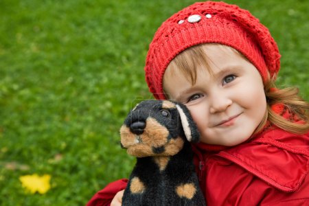 Little girl with a toy dog in park