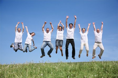Seven friends in white T-shorts jump together