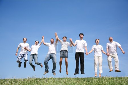 Group of friends in white T-shorts jump together