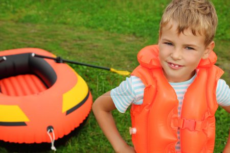 Boy and inflatable boat on lawn