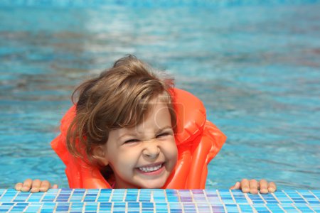 Little girl in inflatable waistcoat in pool