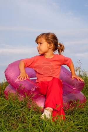 Girl looking at the sky in inflatable armchair