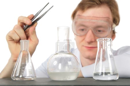 Chemist with tweezers and three flasks