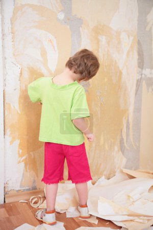Little girl remove old wallpapers