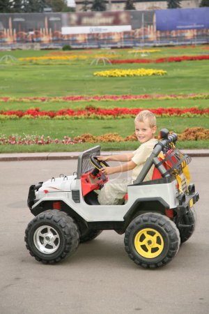 Boy in toy car in park