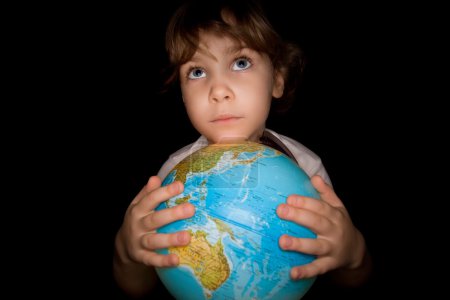 Little girl keeps in hands over globe of world isolated on black