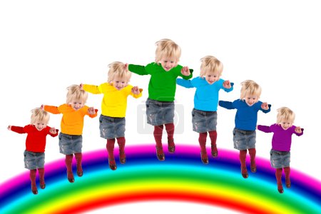 Children with rainbow color dress are jumping on the rainbow, co