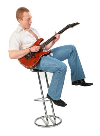 Young man with guitar on chair