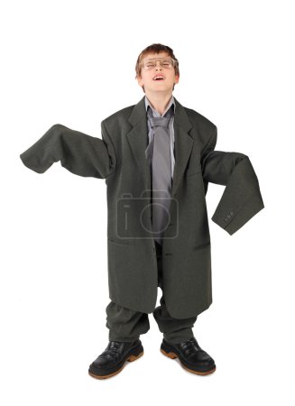 Little boy in big grey man's suit, boots and glasses floor isola