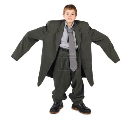 Little boy in big grey man's suit and boots nads at sides isolat