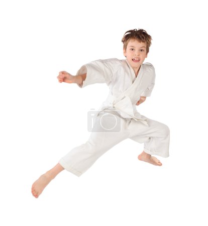 Karateka boy in white kimono jumping isolated on white backgroun
