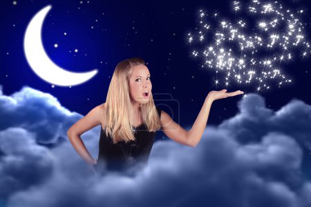 A girl holds something on a hand in sky with a moon and stars