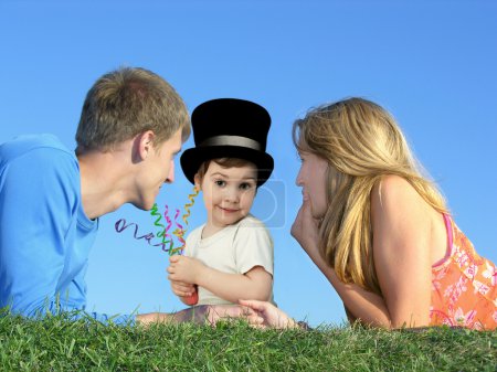 Child in a hat with a mother and father on a grass, collage