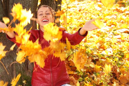Girl throws yellow maple leaves