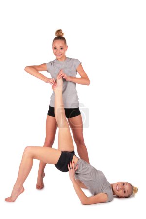 Twin sport girls. holding lying sister's leg