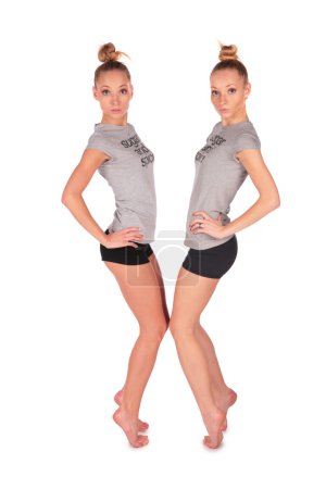 Twin sport girls stands on tiptoe face-to-face