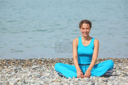 Woman is making exercise on sea coast